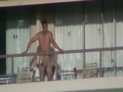 A scene from a spy film shows a strong, muscular man banging his lustful, unfaithful wife on a balcony.
